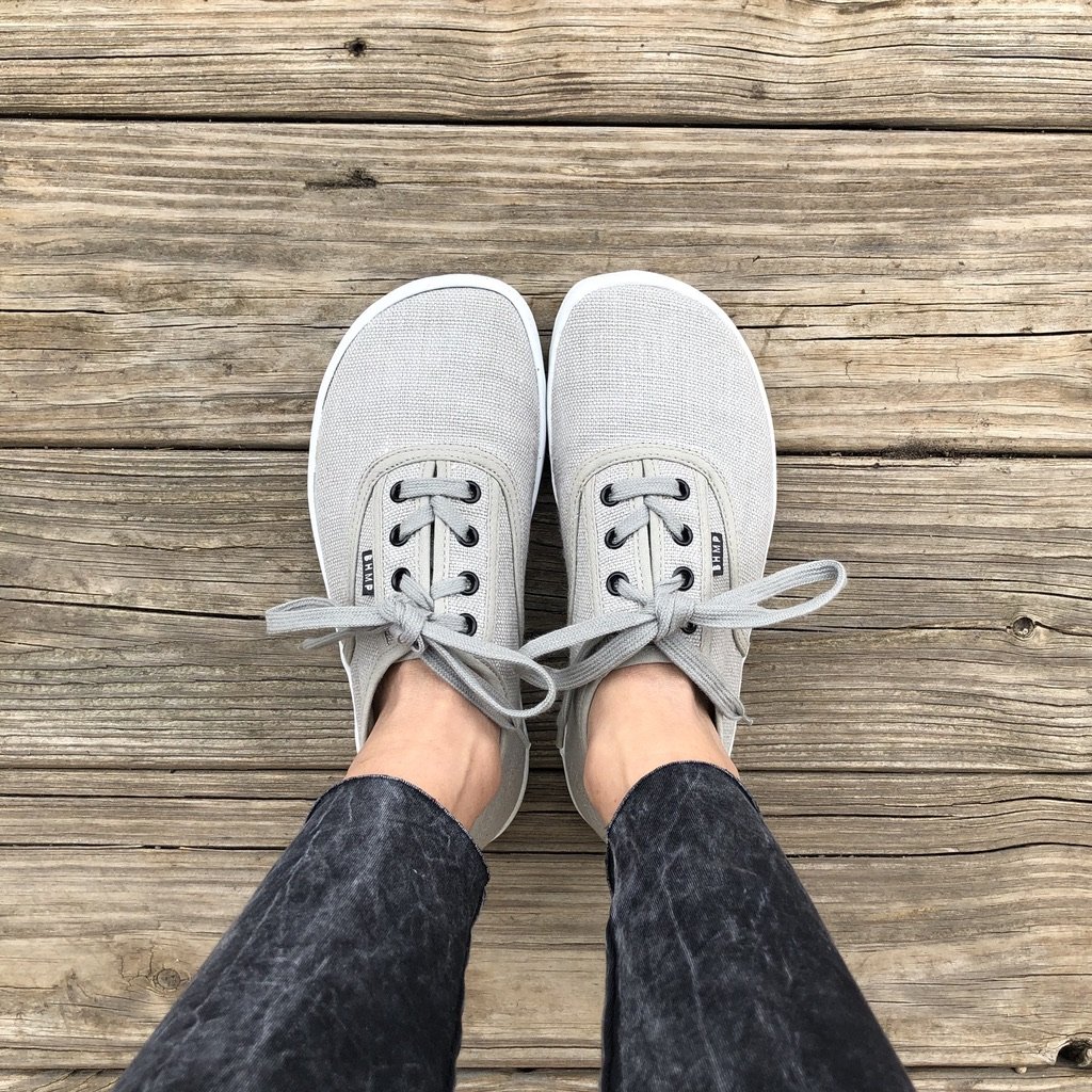 A top down view of a pair of feet wear Bohempia barefoot vegan casual  sneakers, model Kolda in grey hemp.