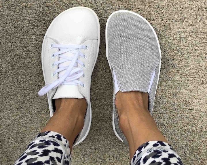 Close up view of the Belenka Barefoot prime white casual barefoot sneaker on one foot and Belenka Eazy slip on in Sand on the other foot