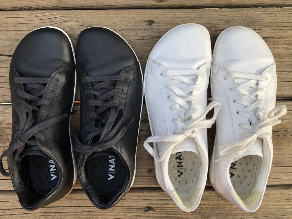 Vivobarefoot Geo Court casual barefoot sneakers review shown in black and white sitting on a wood deck.