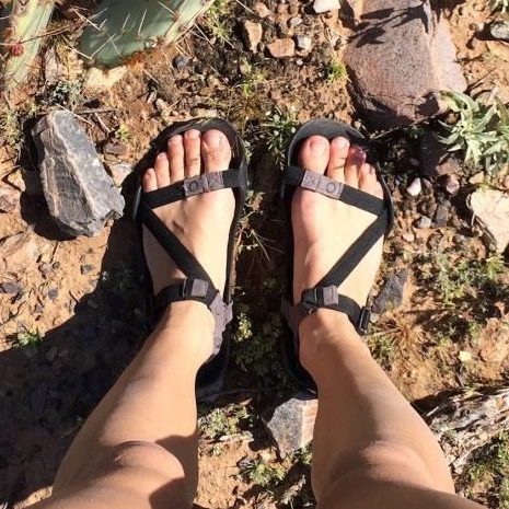 Top down view of a pair of feet out in nature wearing Xero Z Treks in black