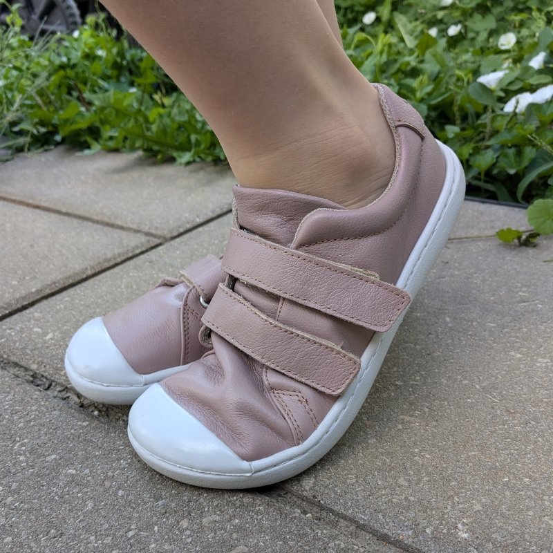 Side close up of a pair of dusty pink leather kids barefoot sneakers from Origo Shoes with a rubber toe cap and flexible flat outsole