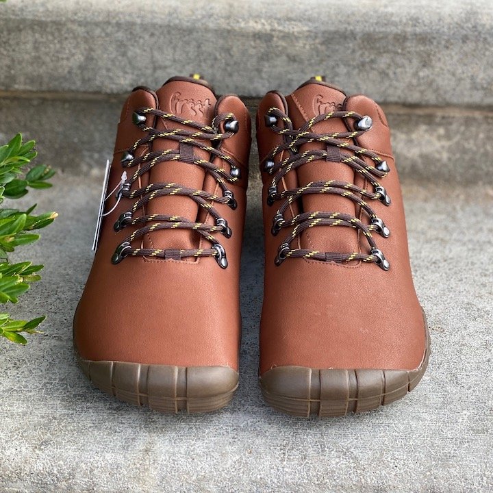 a close up of a pair of freet mudee vegan in brown sitting on concrete