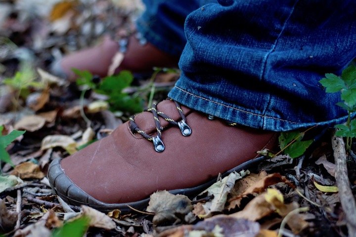 Close up of Freet Mudee, a vegan barefoot hiking boot, standing on dry leaves.