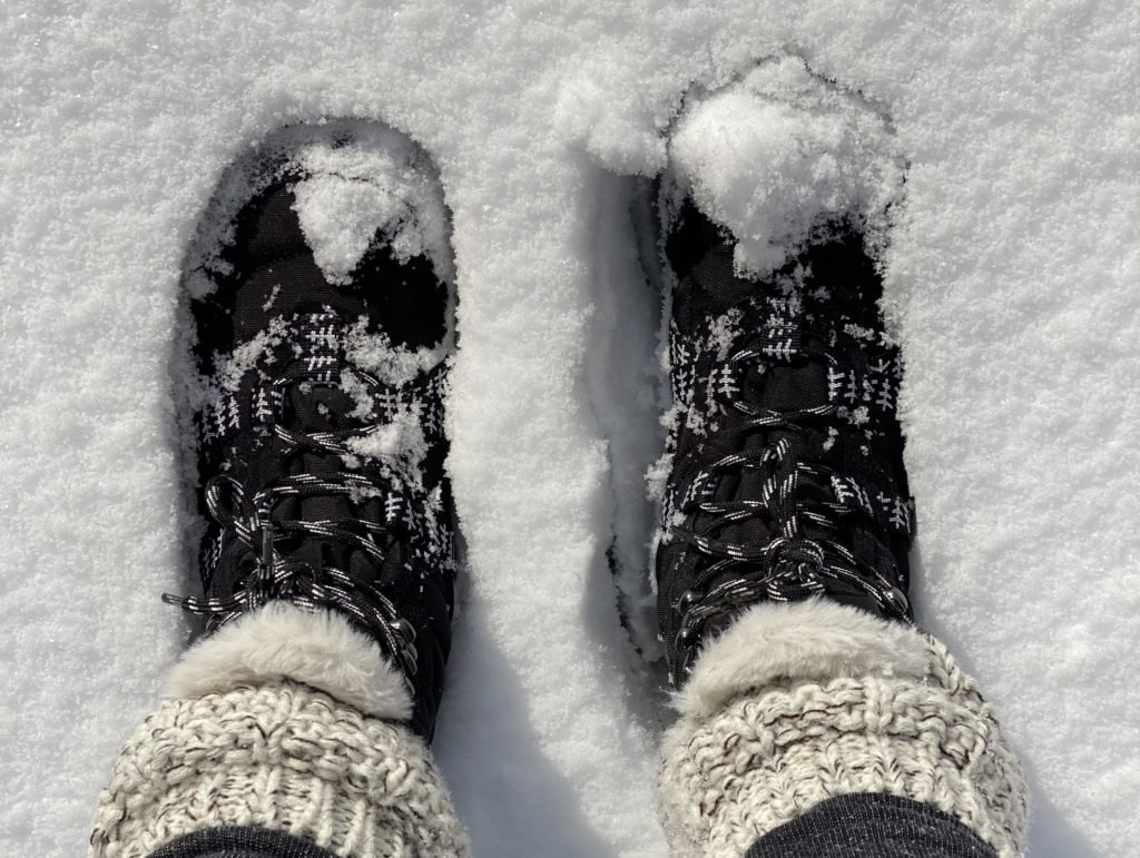 Female feet in boots and leggings, winter walking in snow Stock