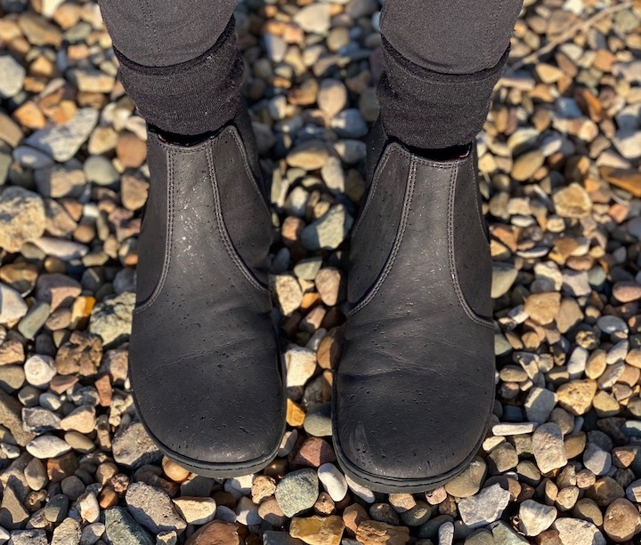 A pair of feet wearing vegan Mukishoes Chelsea barefoot boots in a review.