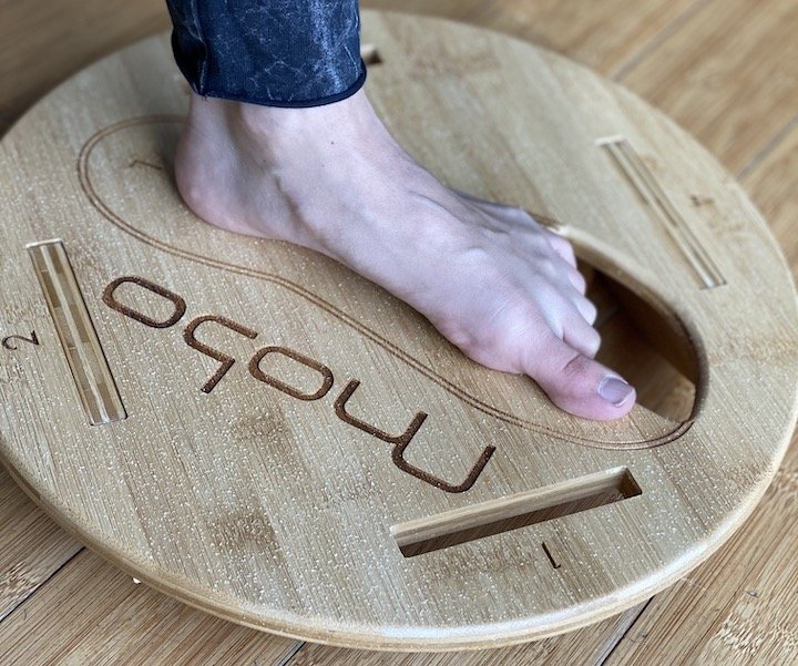 A close up of a woman's foot on a Mobo Balance Board