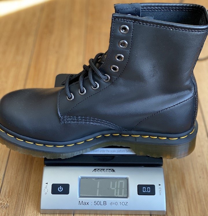 One Doc marten Combat boot on a scale. The weight reads 1 pound, 4 oz.