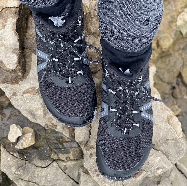 A top down view of a person wearing Xero Xcursion barefoot hiking boots climbing on rocks.