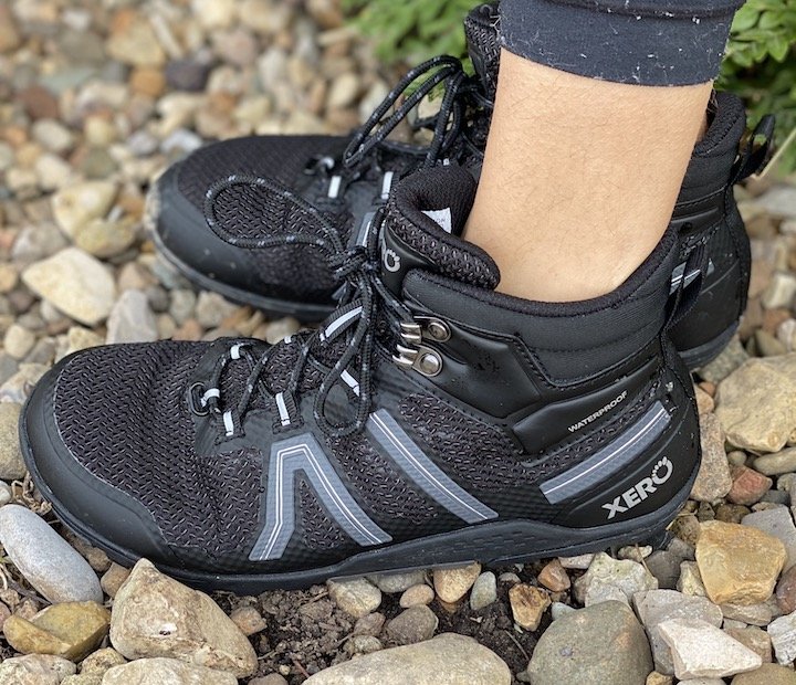 A side angled view of a pair of legs wearing Xero Xcursion waterproof hiking boot