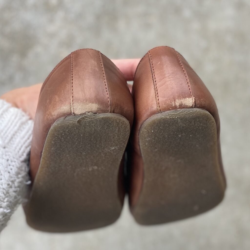 Close up on the heels of FeetSutra Khussa brown leather loafers. The leather at the bottom and the rubber sole is starting to wear down after minimal use.