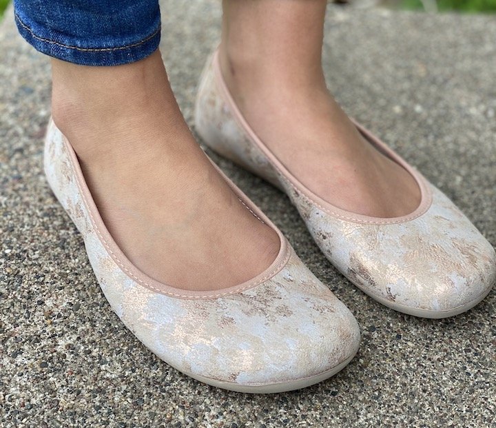 Close up of a woman's extra wide feet in Groundies Bella ballet flats in rose gold