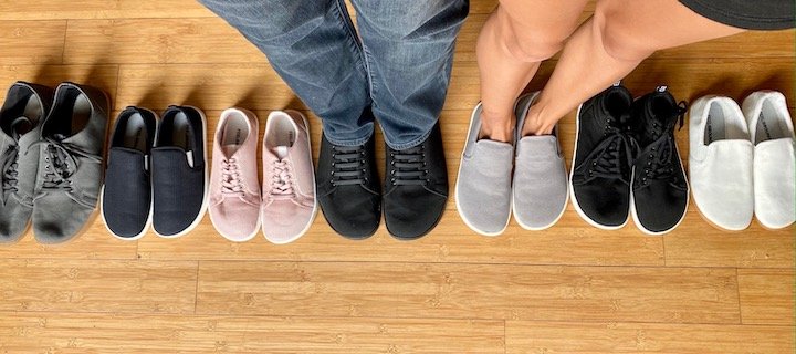 top down view of a man and woman standing in Feelgrounds sneakers amongst a row of 7 pairs of Feelgrounds vegan barefoot shoes