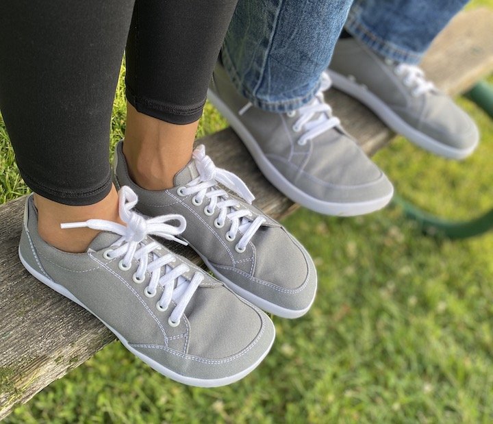 Splay Freestyle affordable athletic sneakers being worn by a man and woman standing on a bench.