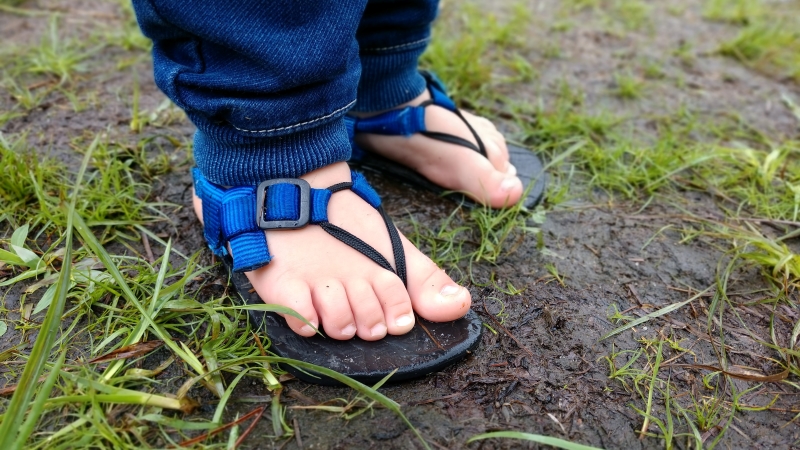 Children's Unshoes Keota Shoes being worn by a toddler on soggy ground