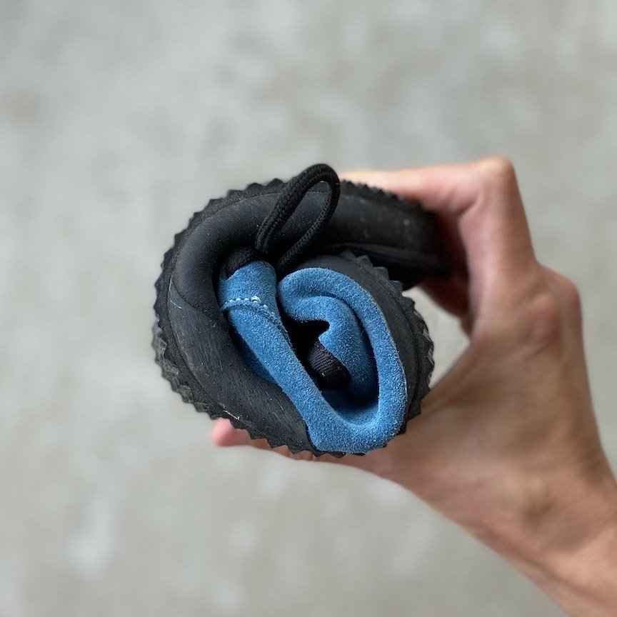 Be Lenka trail walker barefoot hiking shoe rolled up into a tight ball to show the extreme flexibility