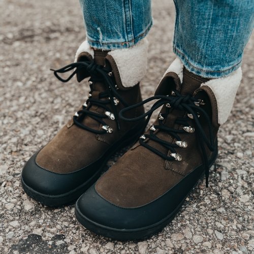 Close up front angled view of new Shapen Lynx stylish barefoot fashion boots in olive and black with cozy cream colored cuff visible around the ankle