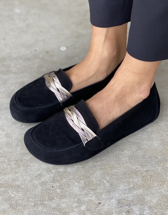 A pair of feet wearing black Zaqq Qerp leather barefoot loafers