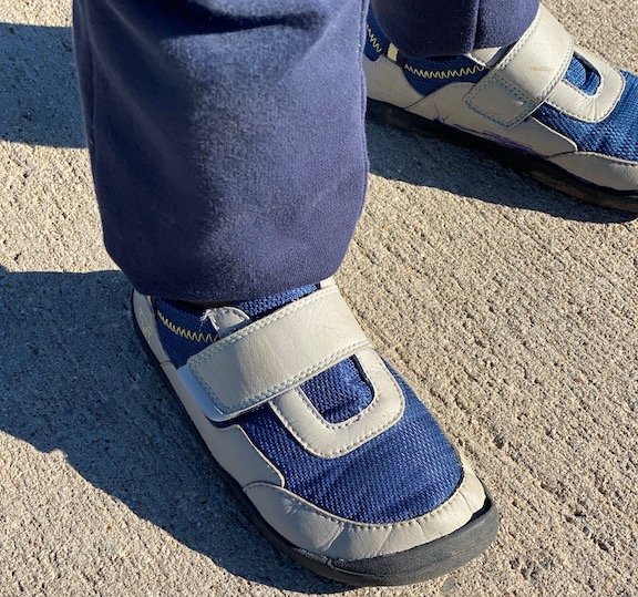 Zuna Leap shoes being worn by a child on cement