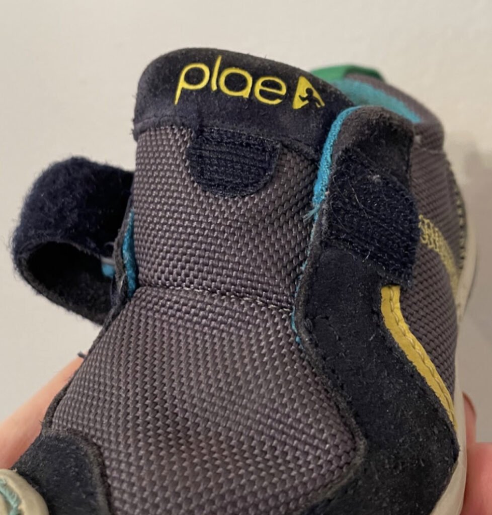 A close up picture of a Plae kids Ty Model shoe tongue with a Velcro closure on it