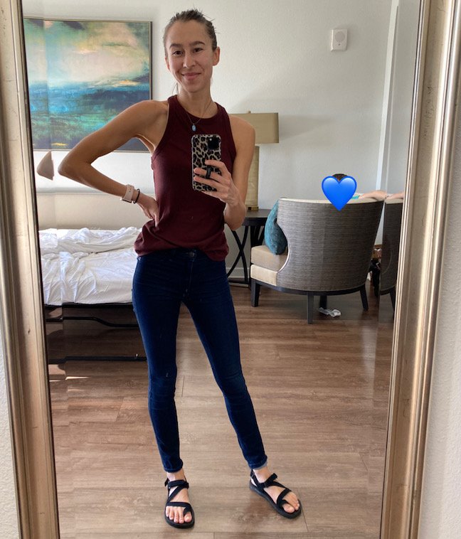 a woman standing and smiling at the camera wearing black vegan Shamma barefoot sandals Trail Stars