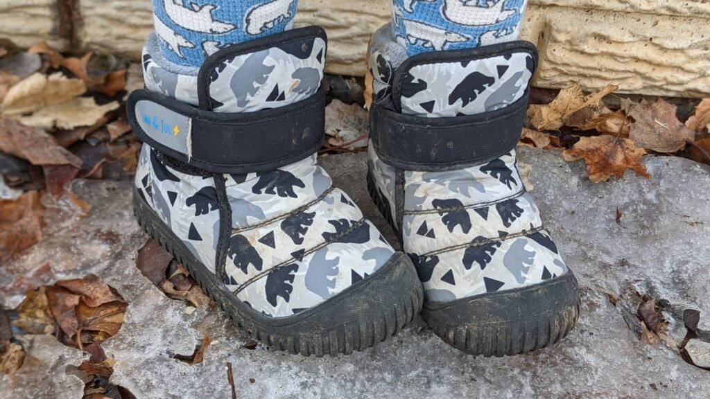 Close up of toddler feet wearing Jan and Jul barefoot friendly affordable snow boots