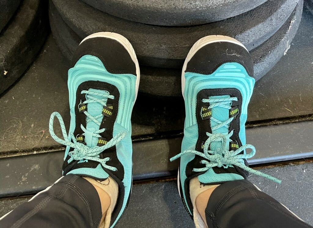 Top down view of a pair of feet wearing Xero Shoes 360 zero drop barefoot cross training sneaker