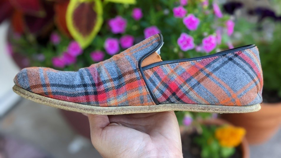 Side profile of plaid barefoot Aintap loafers with leather outsole that has taken on the foot shape of the wearer