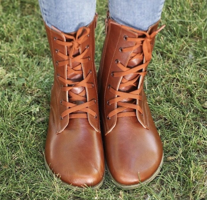 a pair of feet standing on grass wearing brown Barefoot leather lace up boots by FeelBarefoot Etsy shop