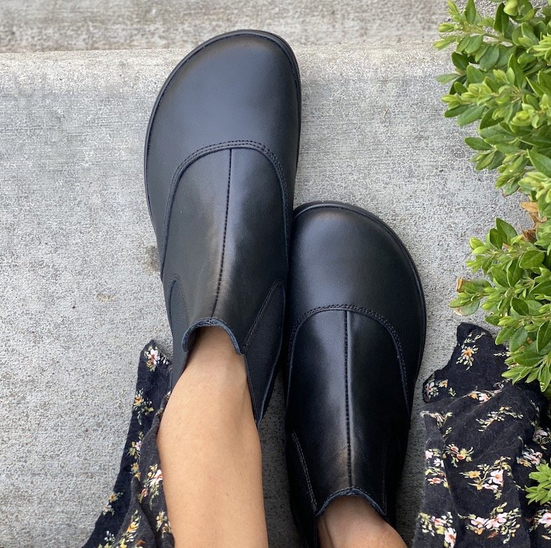 A top down view of a pair of feet wearing black Angles Fashion Artemis barefoot chelsea boots