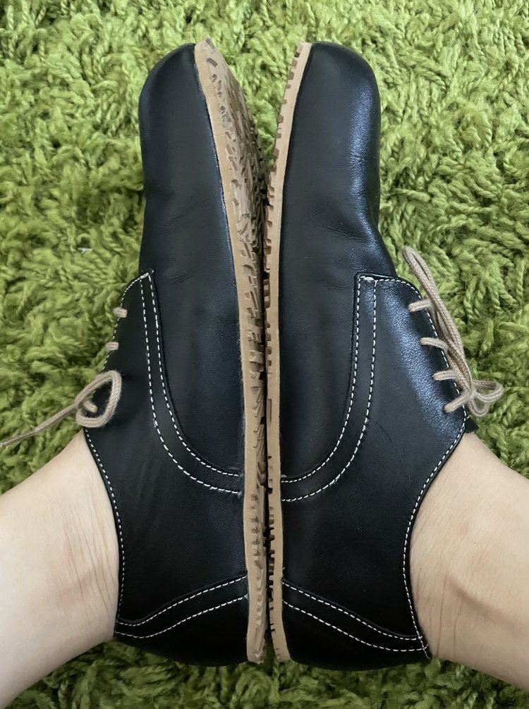 Side view of Nons smooth black oxfords sole to sole to highlight available volume and white stitching on the black leather. The grippy vibram outsole is zero drop.