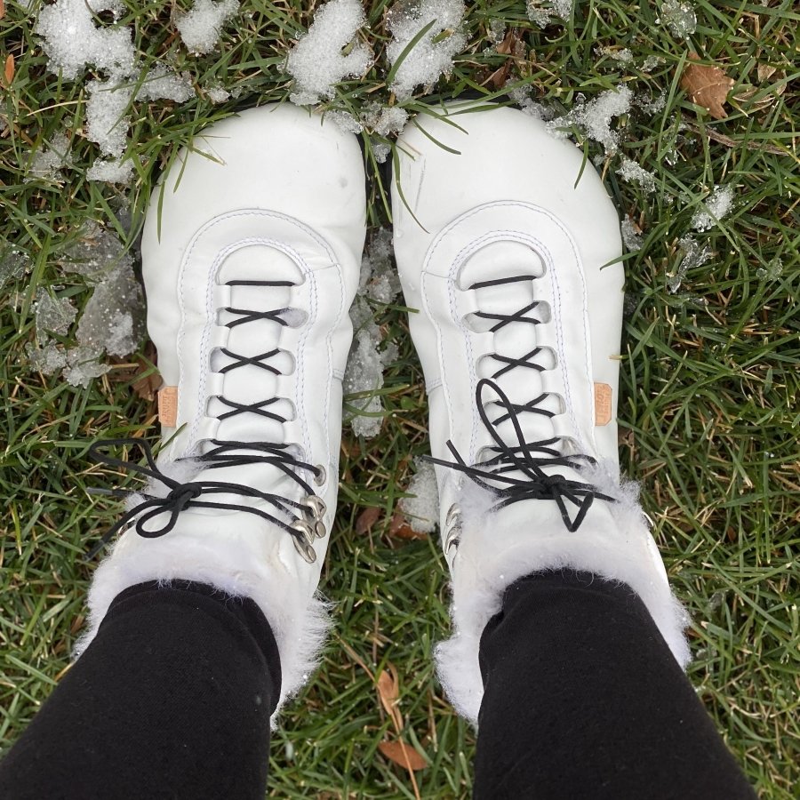 Top down view of Jenon Leather handmade winter warm boots being worn on snowy grass