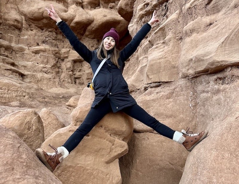 A woman at Goblin Valley park in Utah climbing red rock wearing Be Lenka Bliss brown barefoot winter boots