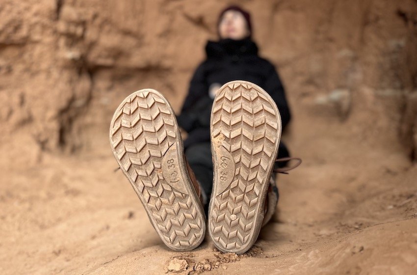 A close up of the soles of a pair of Be Lenka barefoot winter boots to show the lugs and foot shape