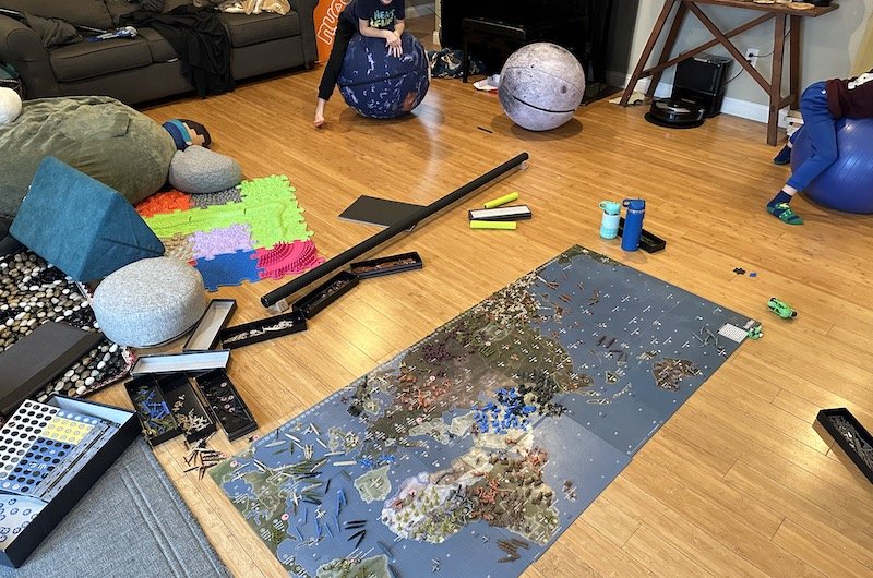 A messy living room with floor seating and foot texture