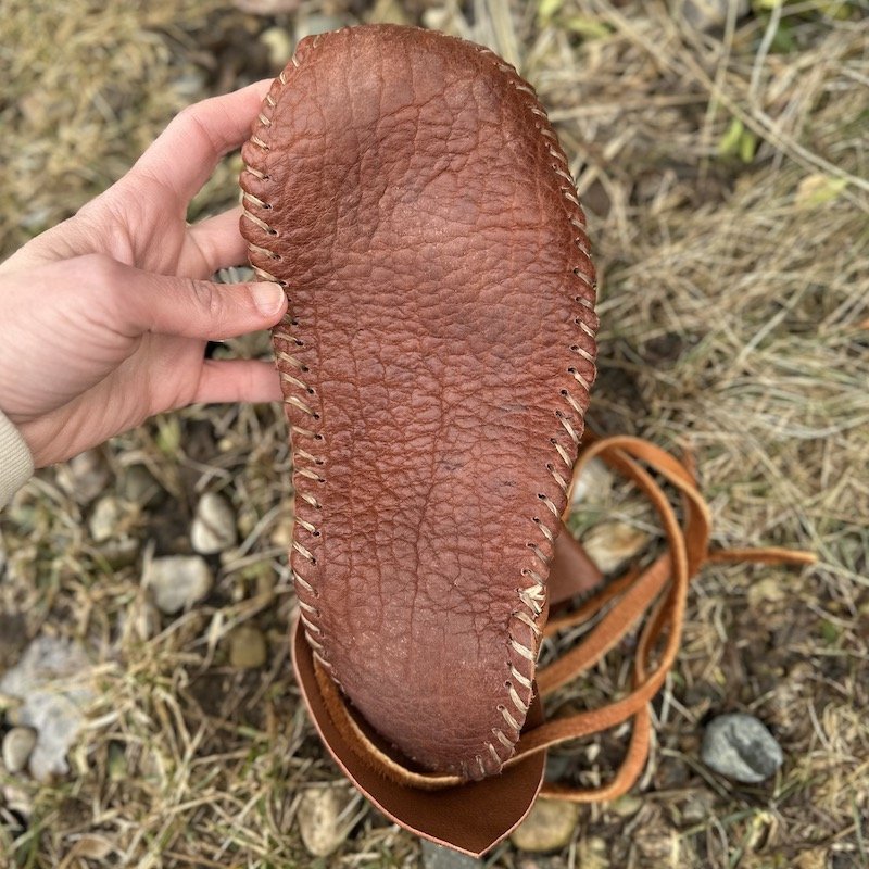 The leather sole of a pair of barefoot moccasins with a wide toe box for grounding from FaeMoon Wolf Designs