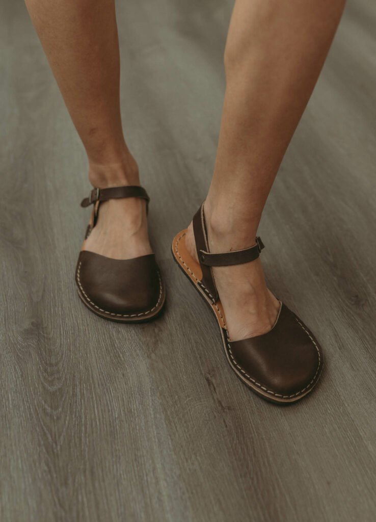 A close up of a woman's feet wearing Crupon barefoot sandals mary jane shoes Trevi Light Grigio