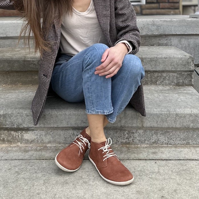 A woman wearing aplaid blazer and Groundies Milano soft cognac desert lace up boots