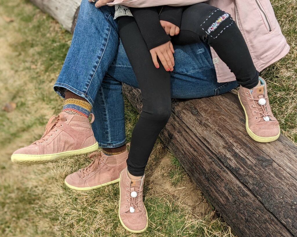 An adult woman with an adult child both wearing Mukishoes Hope sustainable barefoot sneakers with super flexible rubber soles