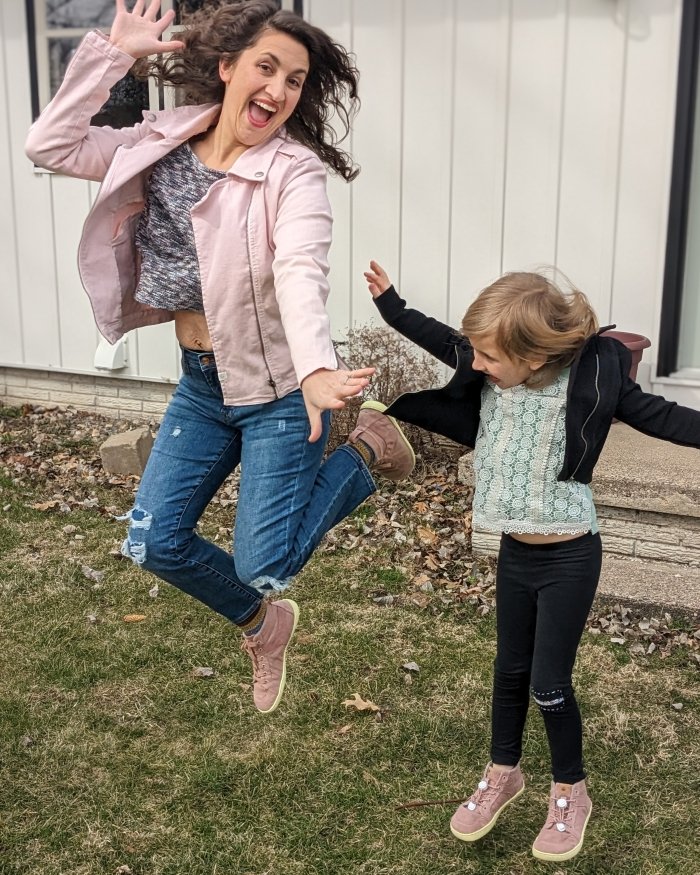 A woman and her daughter wearing Mukishoes Hope sustainable natural material sneakers jumping into the air