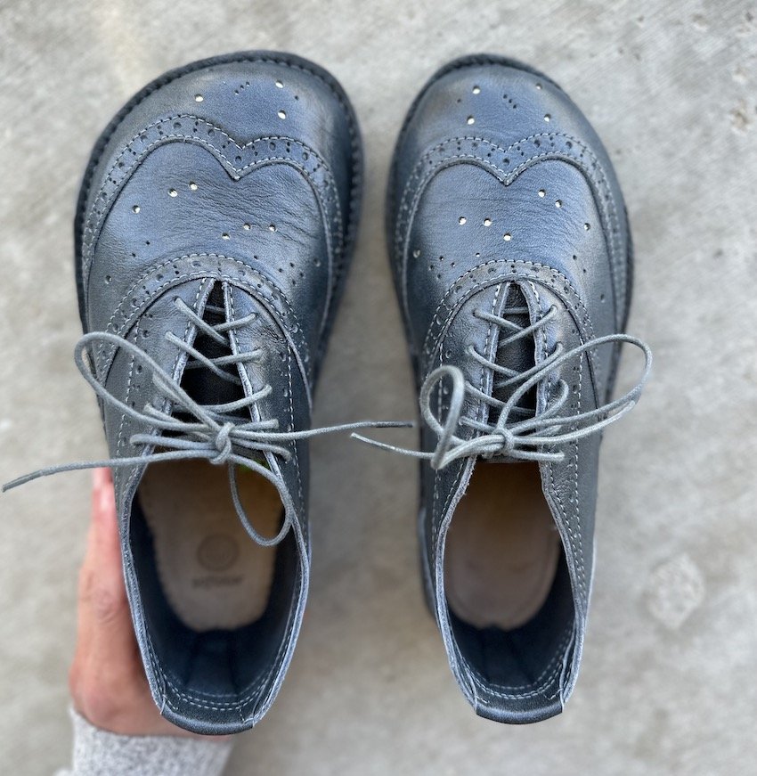 A top down view of one Softstar Oxford Taylor Orion Grey in Wide width with a foot shaped toe box next to the regular width which is narrower