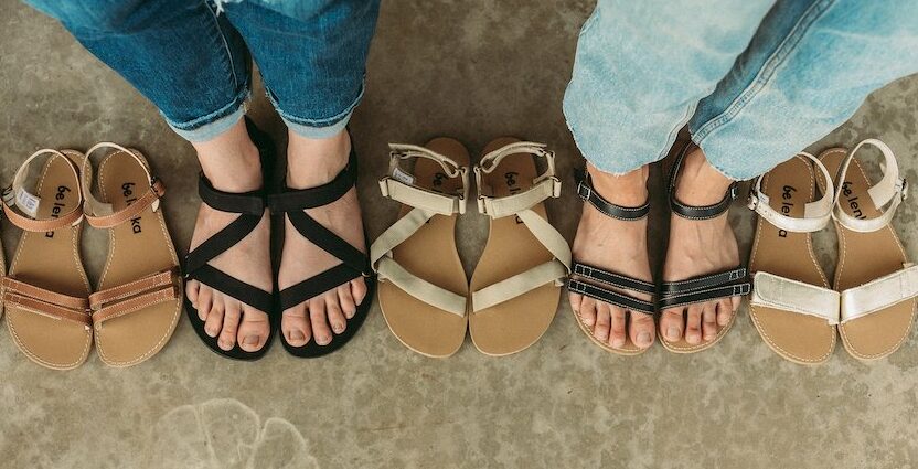 A row of Be Lenka barefoot sandals with two people wearing them, showing that they fit the shape of their feet