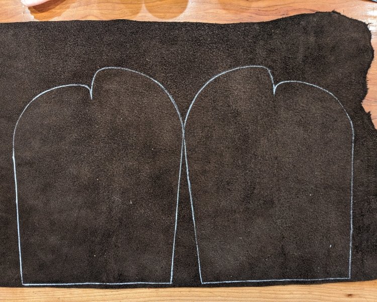 A large piece of leather with a pattern marked out for DIY custom moccasins from Earthing Moccasins kit