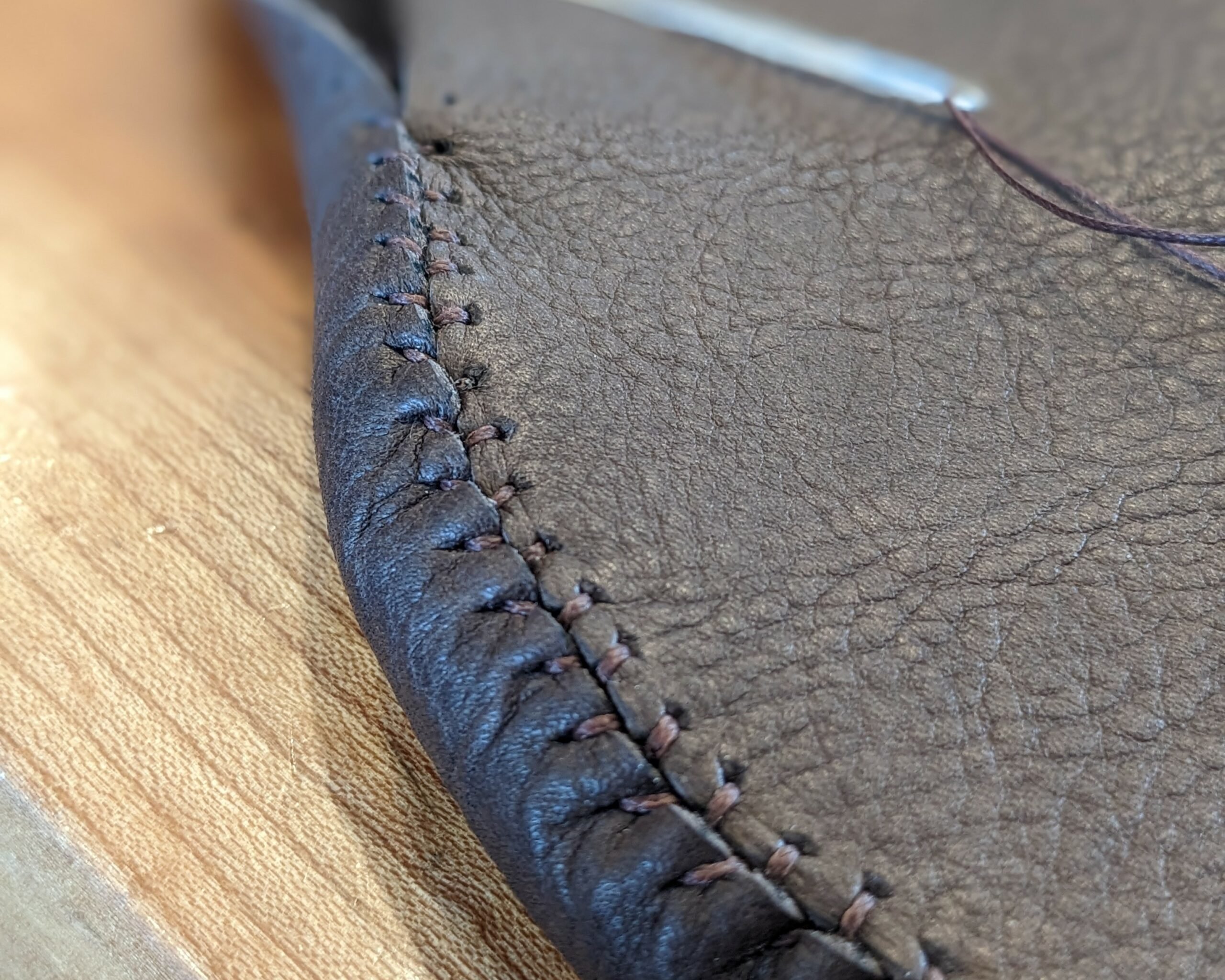 Close up of the flat seam stitch being made on a pair of DIY moccasin made using the Earthing Moccasins leather kit and tutorials