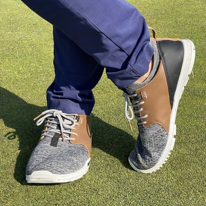 Close up view of a pair of legs on a golf course wearing barefoot zero drop wide toe box golf shoes by True Linkswear