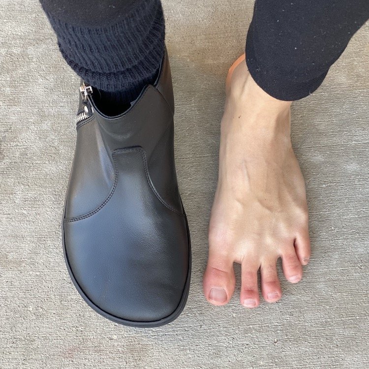 Top down view of a woman with wide feet wearing 1 Shapen Ivy barefoot dressy boots for women with extra wide toe box and zipper for easy access