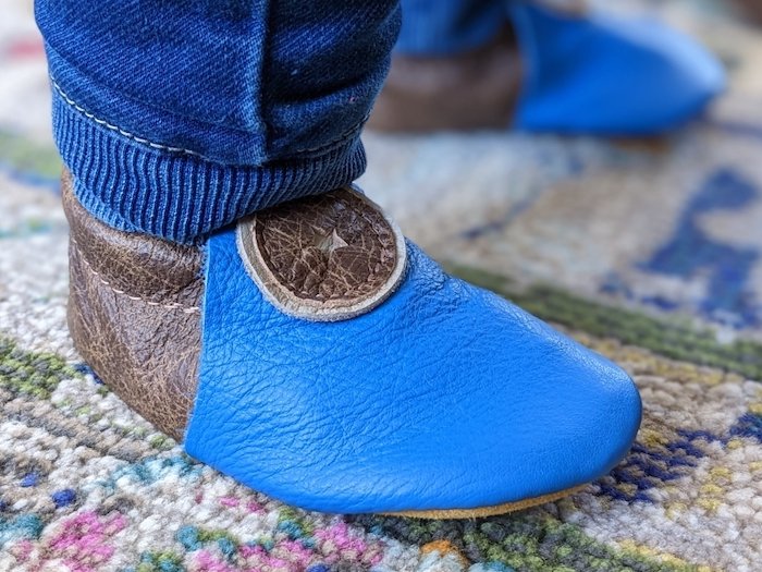 A close up of a toddler wearing Softstar Roo moccasins barefoot shoes for indoor daycare