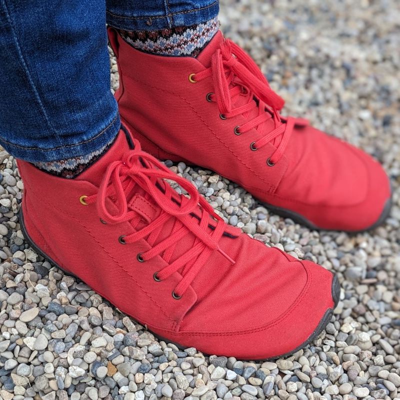 a close up angled side view showing the Wildling Shoes paprika barefoot boot for fall 2023 in a bright coral color