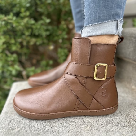 Straight side view of Shapen Divine leather barefoot boots ankle strap and gold buckle on a flat flexible outsole