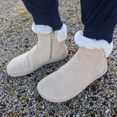 Front angled view of Shapen Fluffy barefoot warm barefoot boots for winter. The back foot is forward to show the inside zipper for easy on/off. The faux fur collar is visible over navy pants