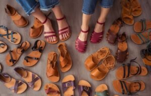 A flat lay of a variety of colorful beautiful Crupon barefoot sandals and flats in different colors and styles, and both barefoot and extra wide width